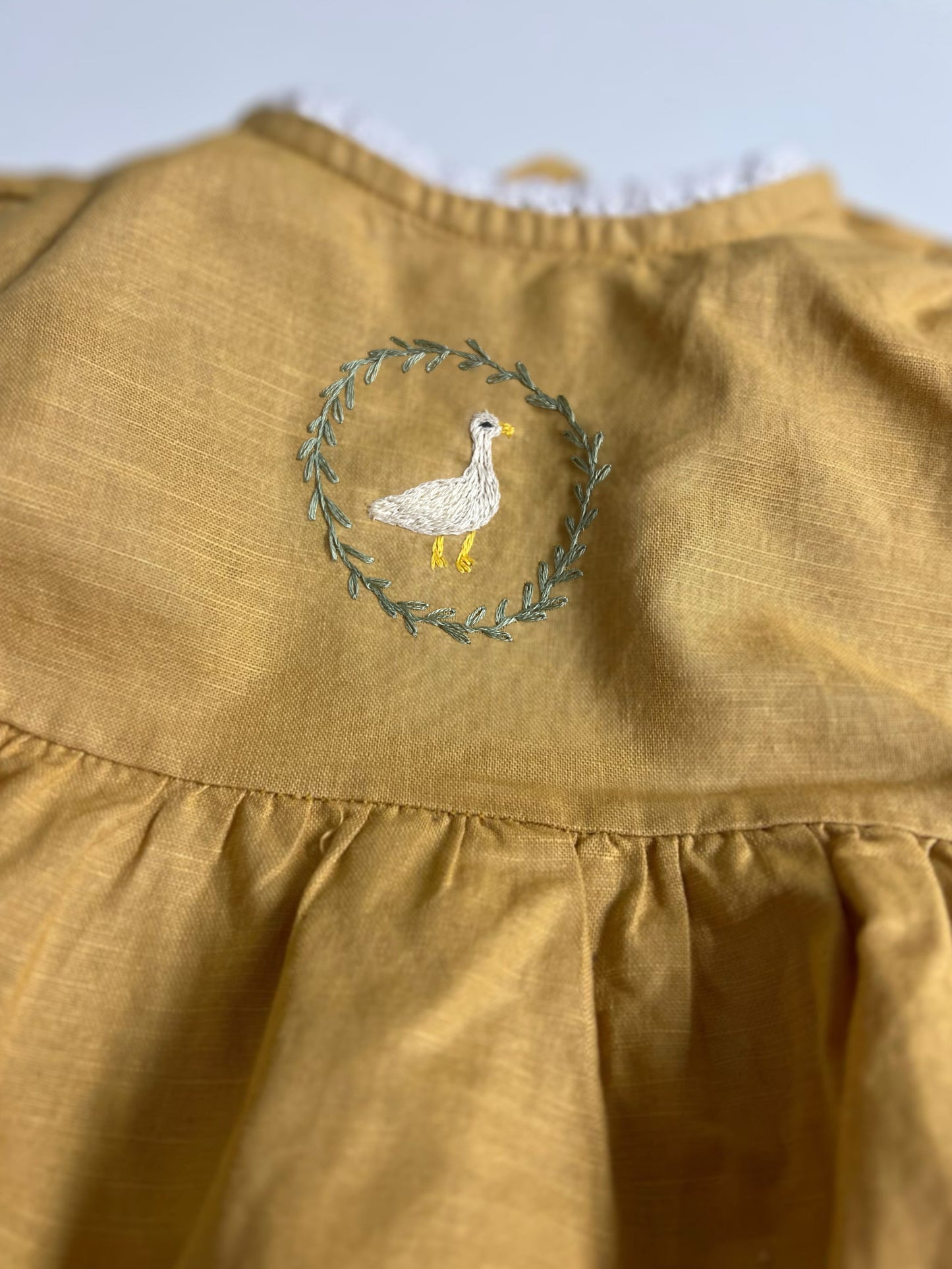 Goose in the Garden | Hand-Embroidered Linen Romper | 6–12 months